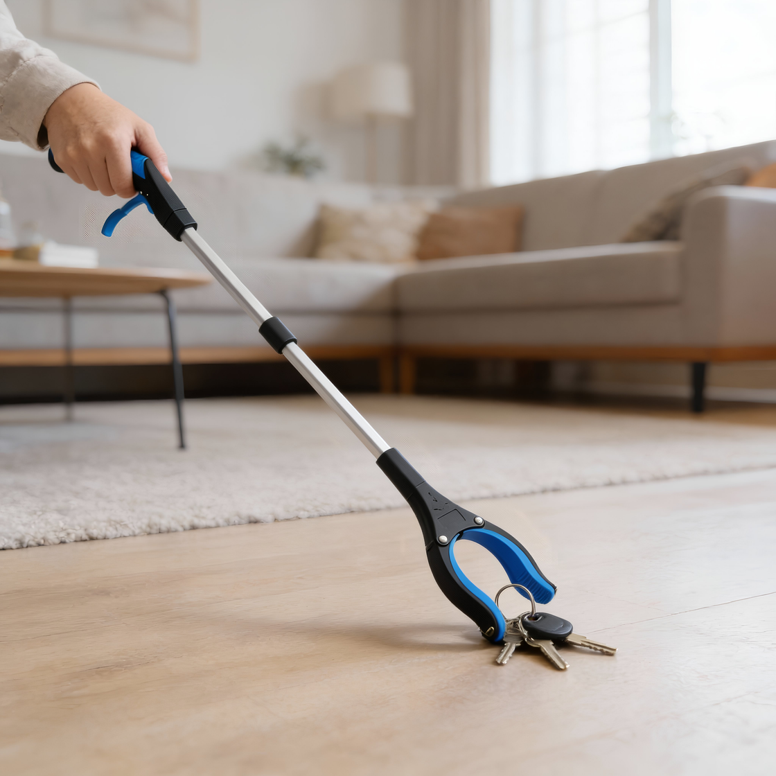 Everyday reacher tool picking up keys from the floor using the gripping claw